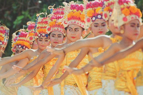 Colorful Balinese dancers performing a traditional ceremony in Indonesia.