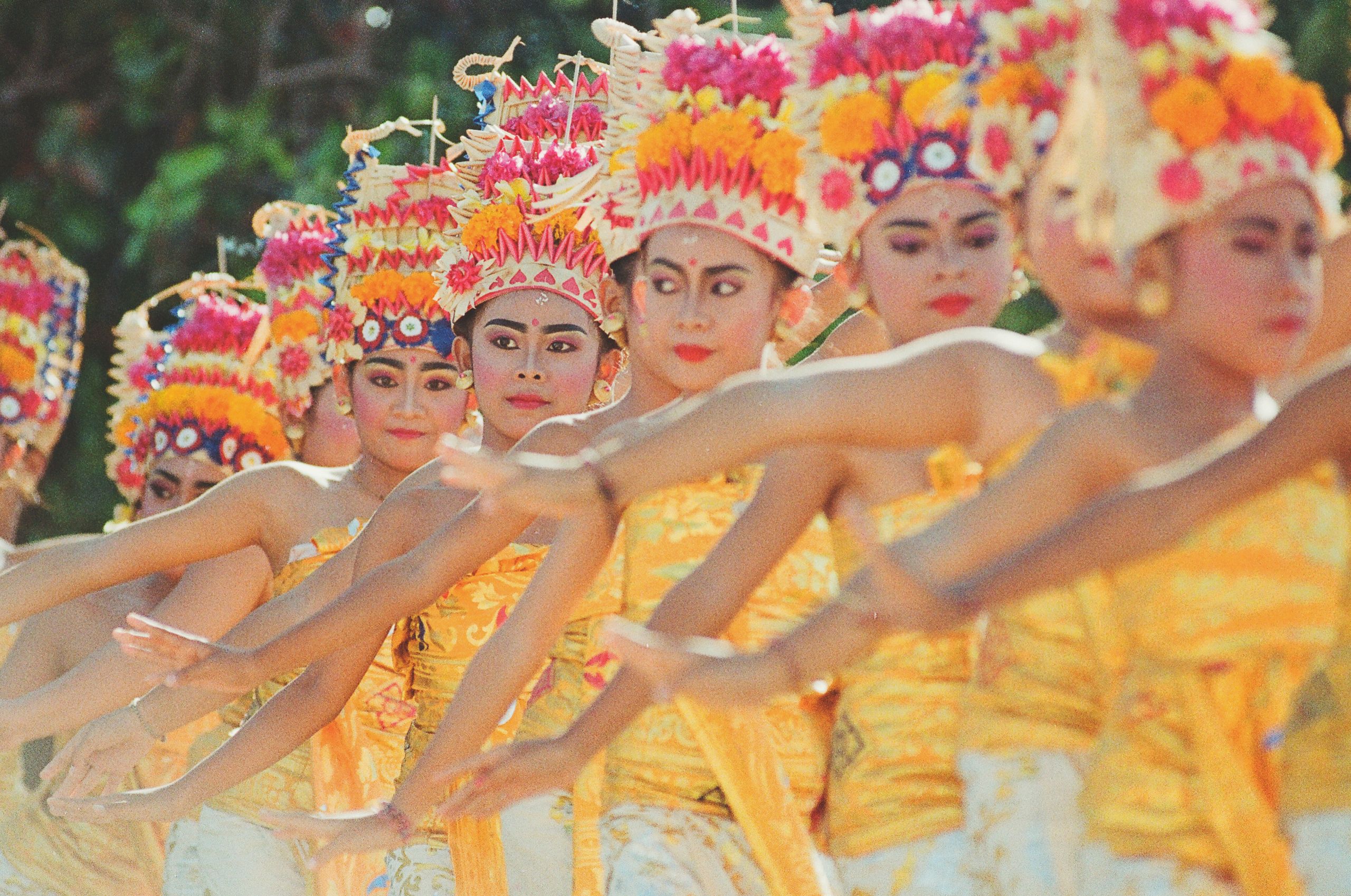 Colorful Balinese dancers performing a traditional ceremony in Indonesia.